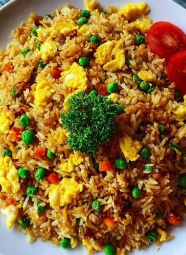 Delicious bowl of Egg Fried Rice garnished with vegetables and herbs
