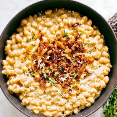 Bowl of delicious French onion macaroni cheese topped with crispy onions
