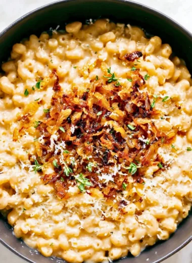 Bowl of delicious French onion macaroni cheese topped with crispy onions