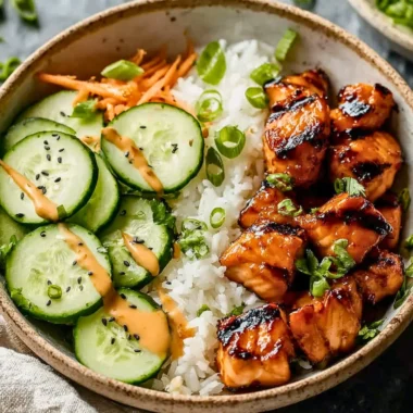 Spicy salmon bowls with fresh vegetables and rice, garnished for a flavorful dish.
