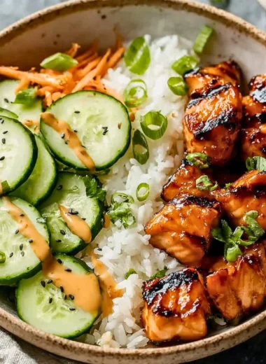 Spicy salmon bowls with fresh vegetables and rice, garnished for a flavorful dish.