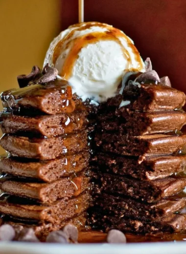 Delicious chocolate protein pancakes stacked with syrup and fruit on top
