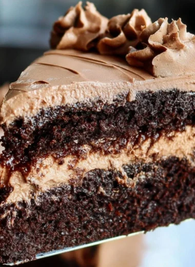 Delicious vegan chocolate cake topped with vegan frosting and fresh berries