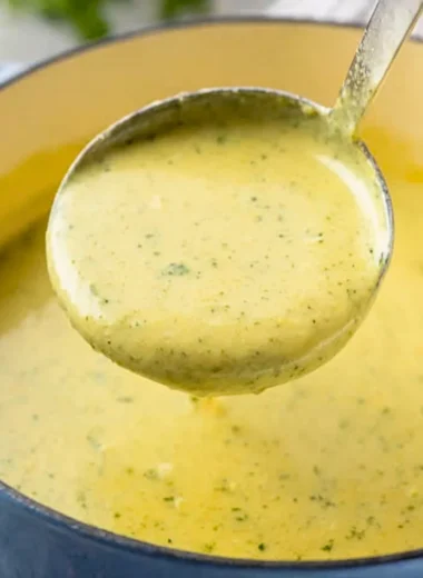 Bowl of creamy zucchini soup garnished with fresh herbs and served with bread