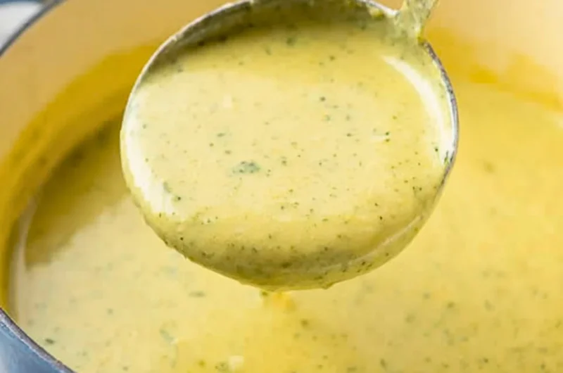 Bowl of creamy zucchini soup garnished with fresh herbs and served with bread