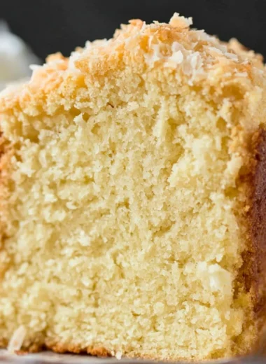 Delicious Coconut Cream Cheese Pound Cake topped with coconut flakes