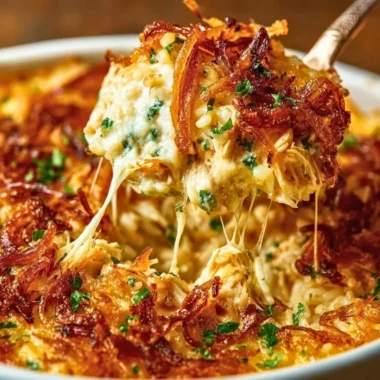 Creamy French Onion Chicken Rice in a white bowl, garnished with herbs.
