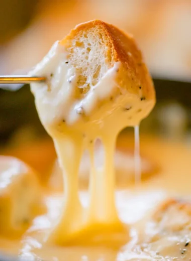 Bowl of easy cheese fondue with bread and vegetables for dipping