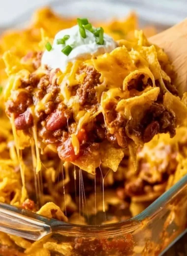 Delicious homemade Frito Pie served in a bowl, topped with cheese and jalapeños.