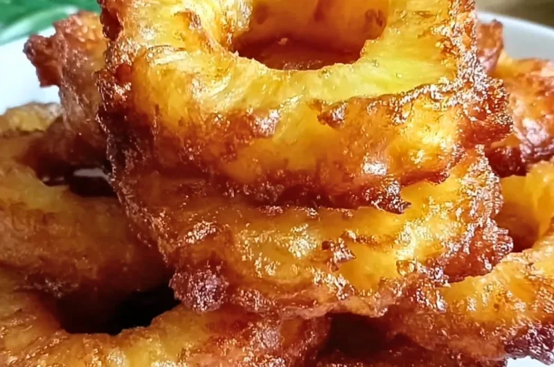 Delicious pineapple fritters topped with powdered sugar and served with a tropical dip