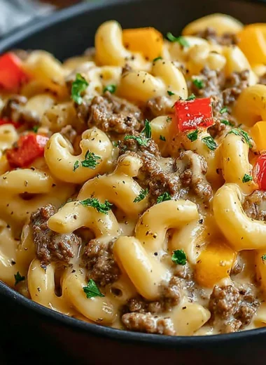 Creamy Philly Cheesesteak Mac & Cheese in a bowl, topped with cheese and herbs.