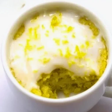 Delicious lemon mug cake served in a white mug with a lemon slice on top