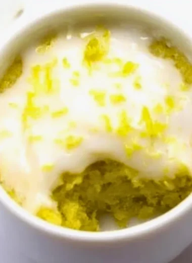 Delicious lemon mug cake served in a white mug with a lemon slice on top