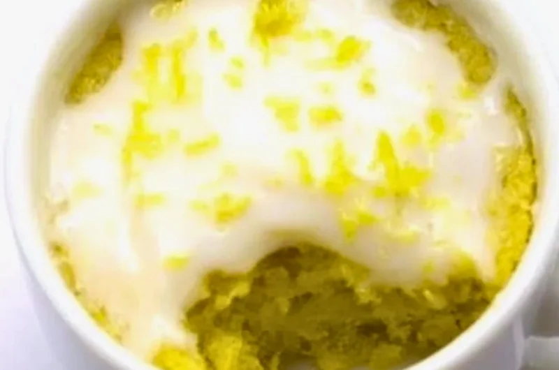 Delicious lemon mug cake served in a white mug with a lemon slice on top