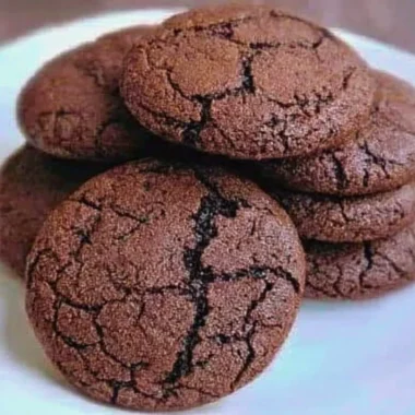 Freshly baked chewy chocolate cookies on a cooling rack.