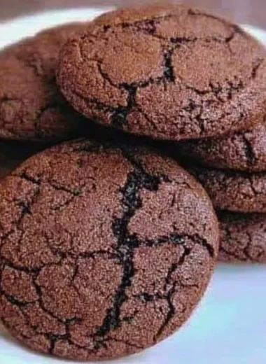 Freshly baked chewy chocolate cookies on a cooling rack.