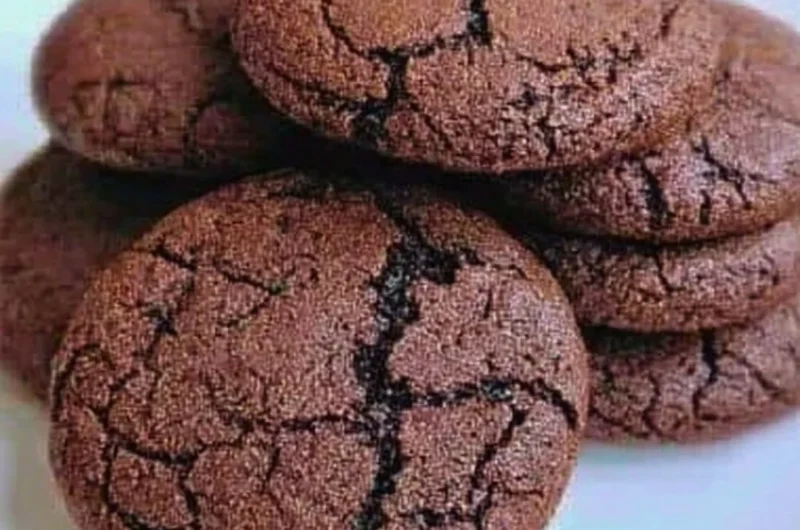 Freshly baked chewy chocolate cookies on a cooling rack.