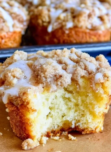 Freshly baked coffee cake muffins topped with a crumbly streusel