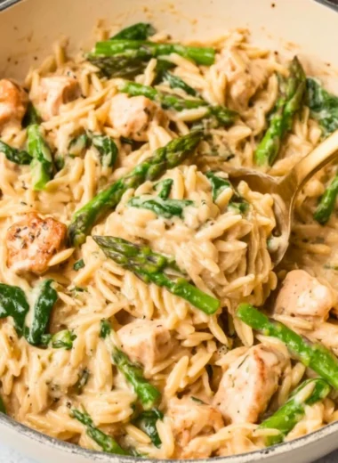 High protein chicken orzo dish garnished with herbs and vegetables