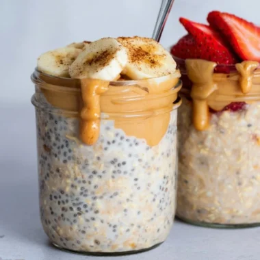 Bowl of high-protein overnight oats topped with fruits and nuts.