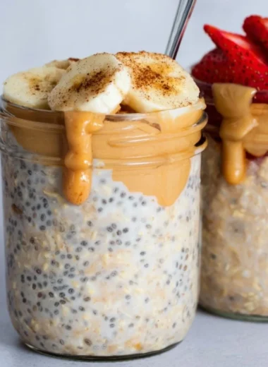 Bowl of high-protein overnight oats topped with fruits and nuts.