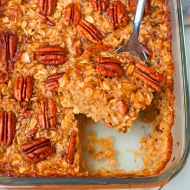 Maple Pecan Baked Oatmeal with nuts and maple syrup on a rustic table.