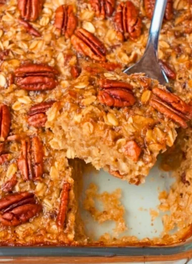 Maple Pecan Baked Oatmeal with nuts and maple syrup on a rustic table.