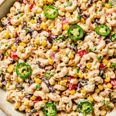 Bowl of colorful Mexican macaroni salad with fresh vegetables and spices