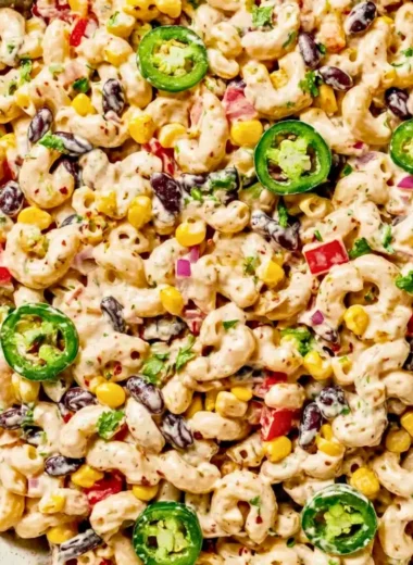 Bowl of colorful Mexican macaroni salad with fresh vegetables and spices