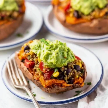 Mexican quinoa stuffed sweet potatoes topped with fresh herbs and spices