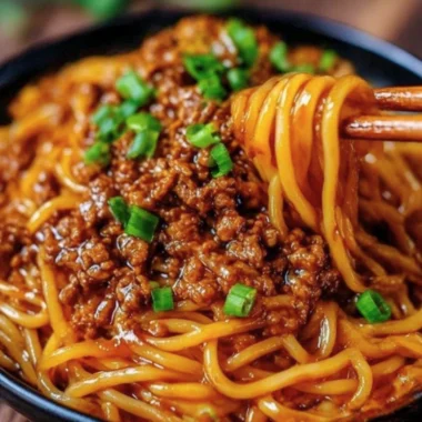 Delicious plate of Mongolian Ground Beef Noodles garnished with green onions.
