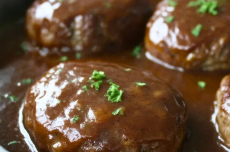 Plate of homemade simple Salisbury steak with gravy and sides