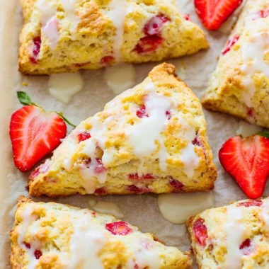 Freshly baked strawberries and cream scones on a plate with strawberries