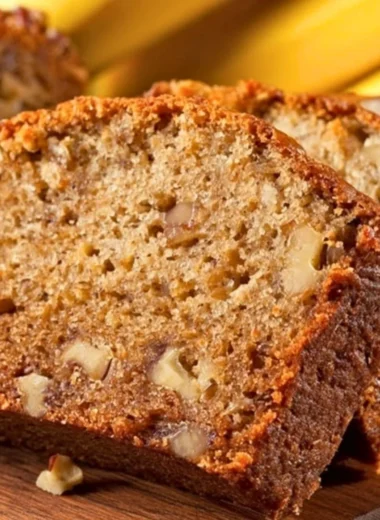 Delicious slice of moist banana bread on a wooden table