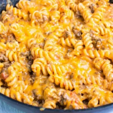 Cheesy taco pasta topped with melted cheese and fresh ingredients