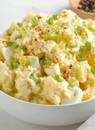 Creamy potato salad in a bowl garnished with herbs