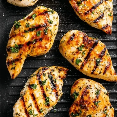 Juicy grilled chicken breast on a plate with herbs
