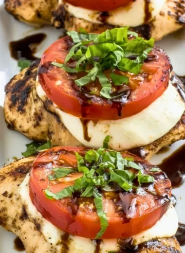 Plate of grilled chicken caprese with fresh tomatoes and mozzarella