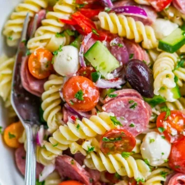 Delicious Italian pasta salad with cherry tomatoes, olives, and fresh basil