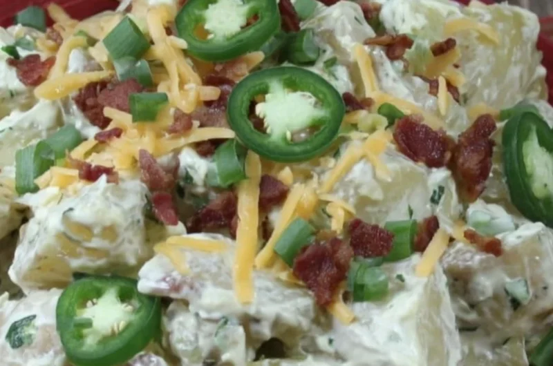 Jalapeño popper potato salad with creamy dressing and garnished with jalapeños.