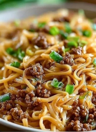 Delicious bowl of Mongolian ground beef noodles garnished with vegetables