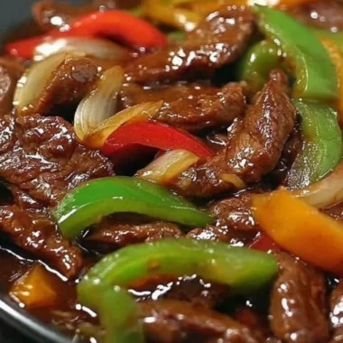 Delicious pepper steak cooked in a crock pot with colorful vegetables.