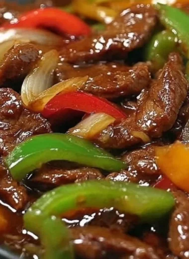 Delicious pepper steak cooked in a crock pot with colorful vegetables.