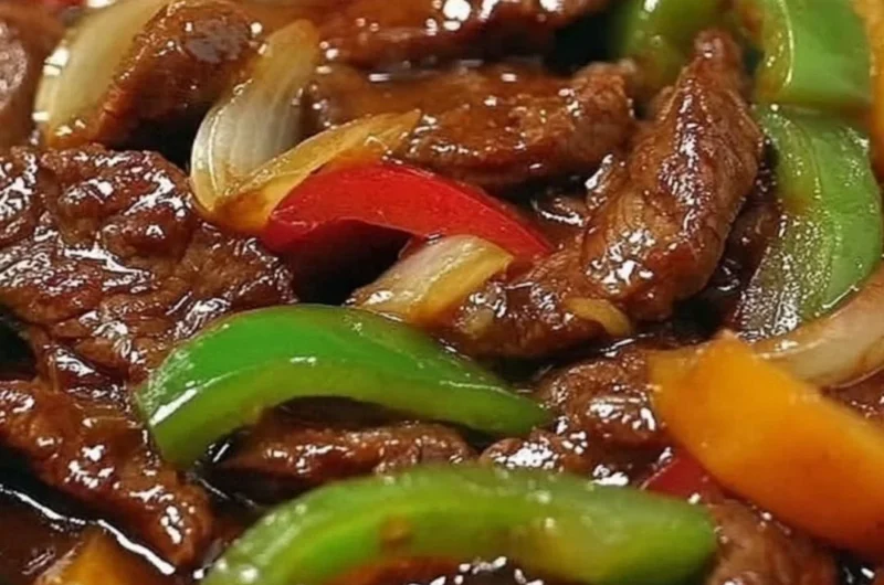 Delicious pepper steak cooked in a crock pot with colorful vegetables.