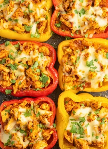 Colorful stuffed peppers filled with chicken and vegetables on a plate.