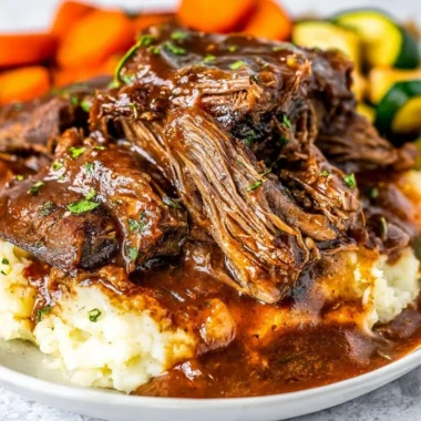 Delicious slow cooker short ribs served with vegetables on a plate.