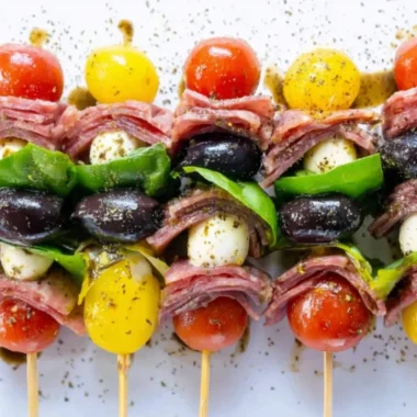A platter of vibrant antipasto skewers featuring olives, cheeses, and vegetables.