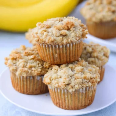 Homemade banana muffins with brown sugar crumb topping on a wooden table