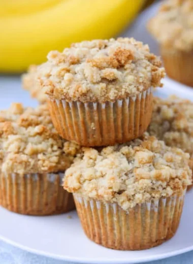 Homemade banana muffins with brown sugar crumb topping on a wooden table