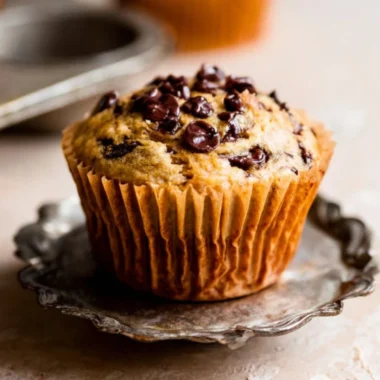 Freshly baked banana chocolate chip muffins on a cooling rack.